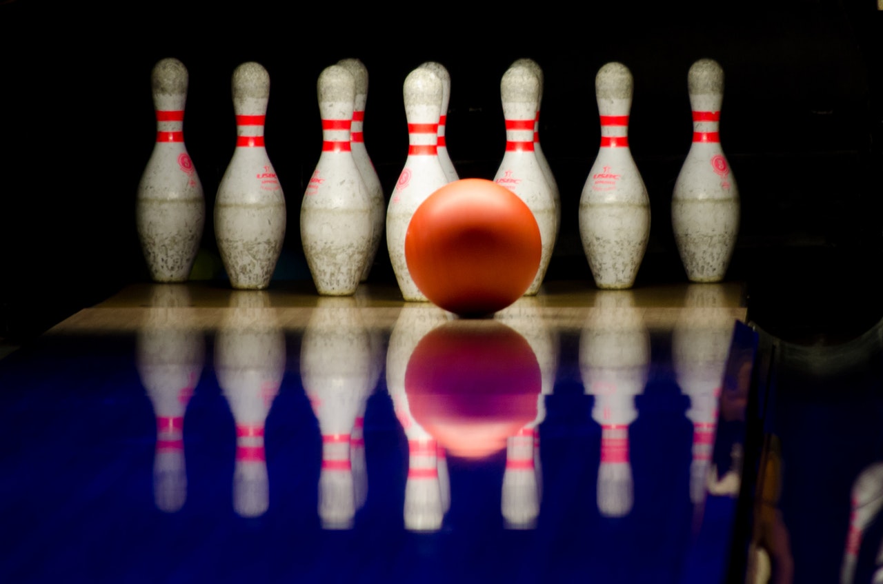 Oransje bowlingkule foran hvite pinner